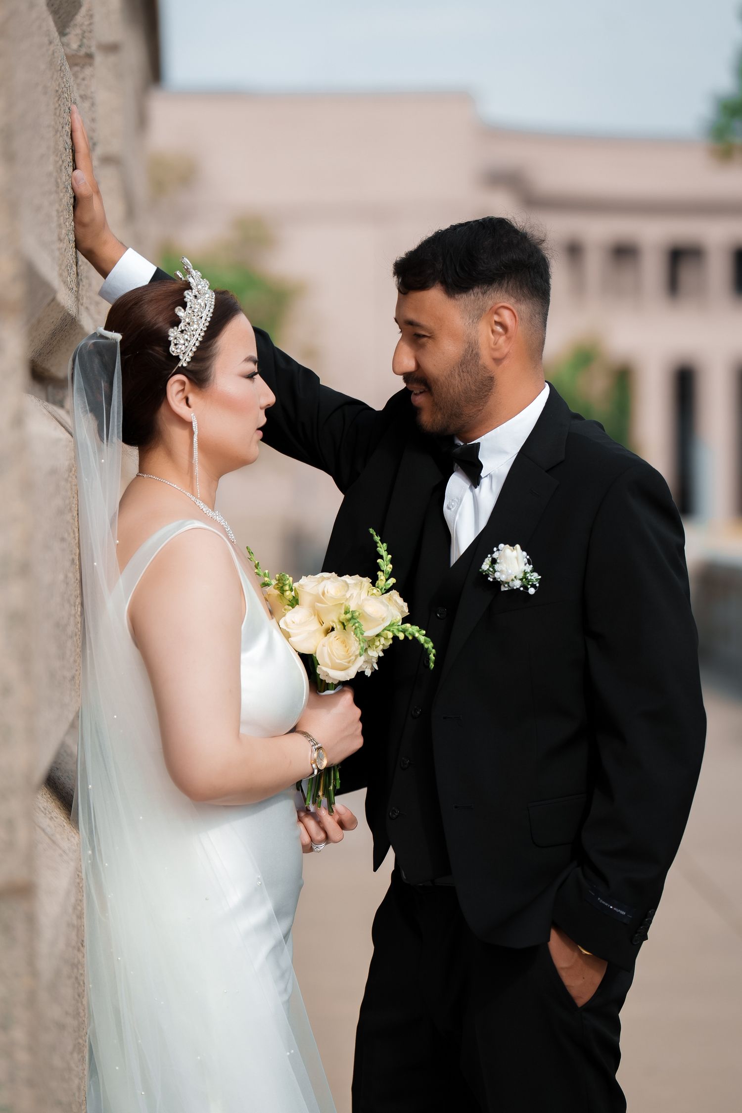 A romantic wedding couple shares intimate moments in a series of elegant black and white portraits outdoors.