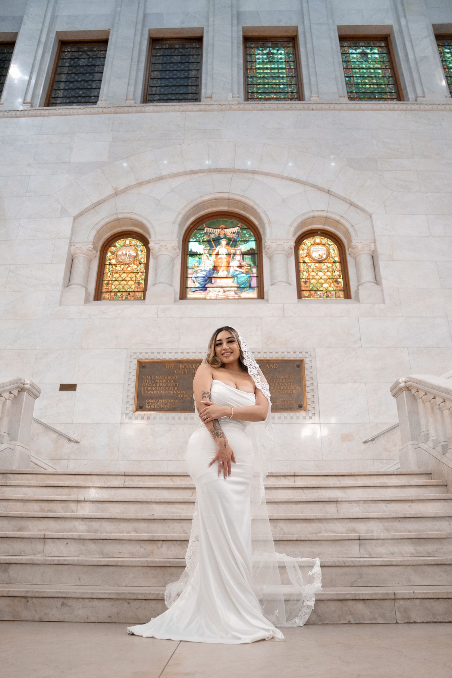 Elegant bridal portraits on white stone steps with stained glass windows in the background.