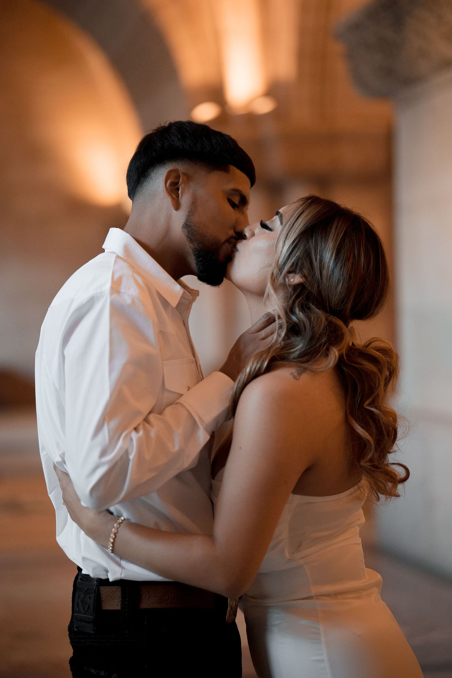 A romantic wedding photoshoot sequence showing a couple embracing in an indoor setting.