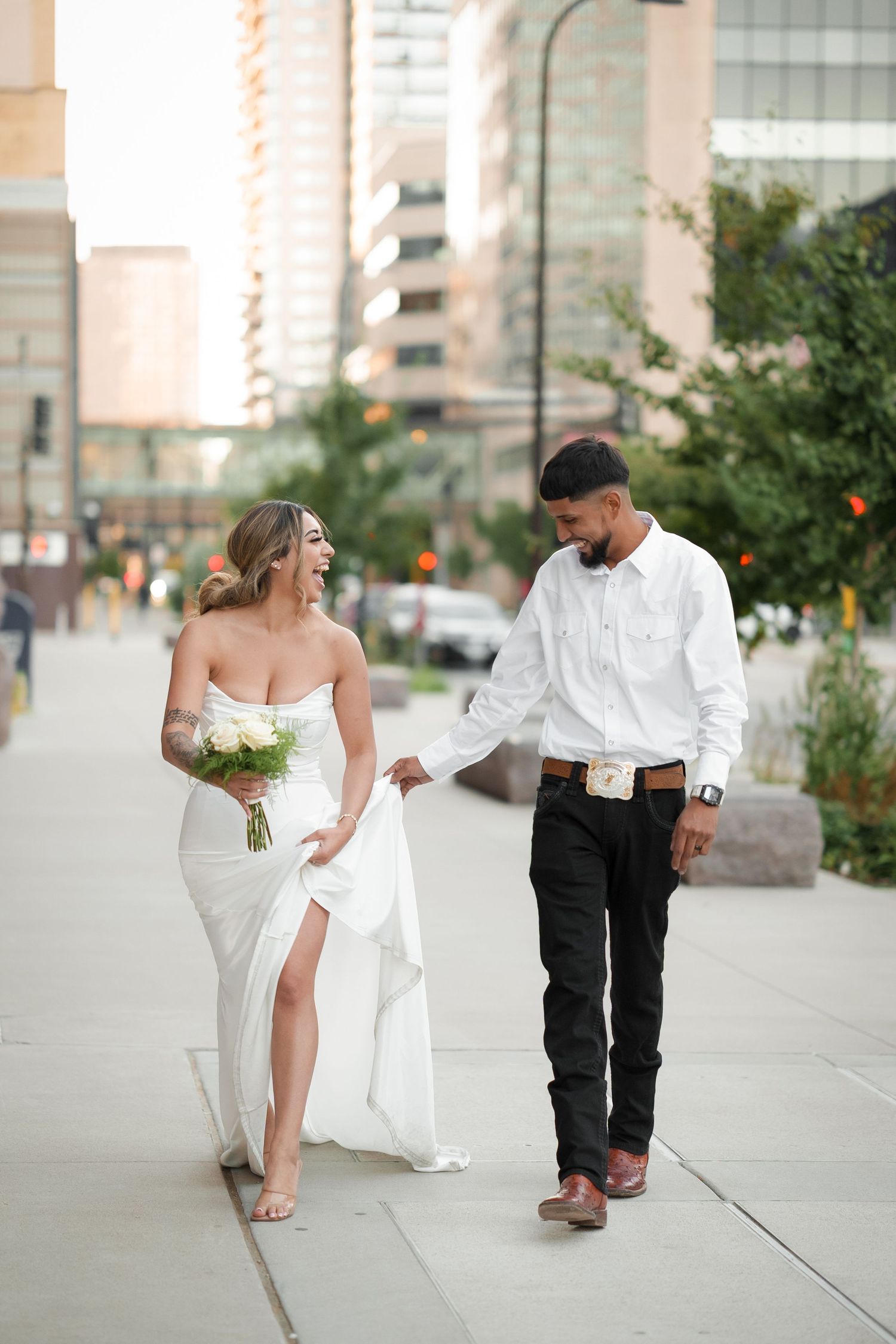 A playful wedding photo sequence on a city sidewalk with urban buildings in background.