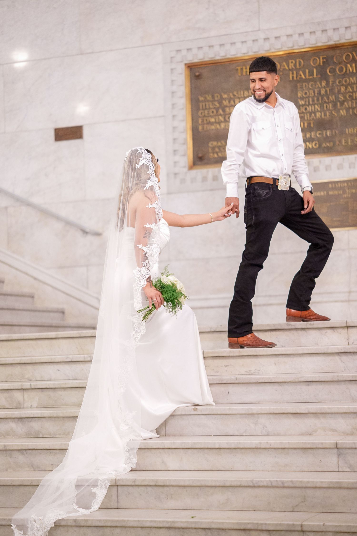Wedding photos captured on grand marble steps with flowing white dress movement and dramatic angles.