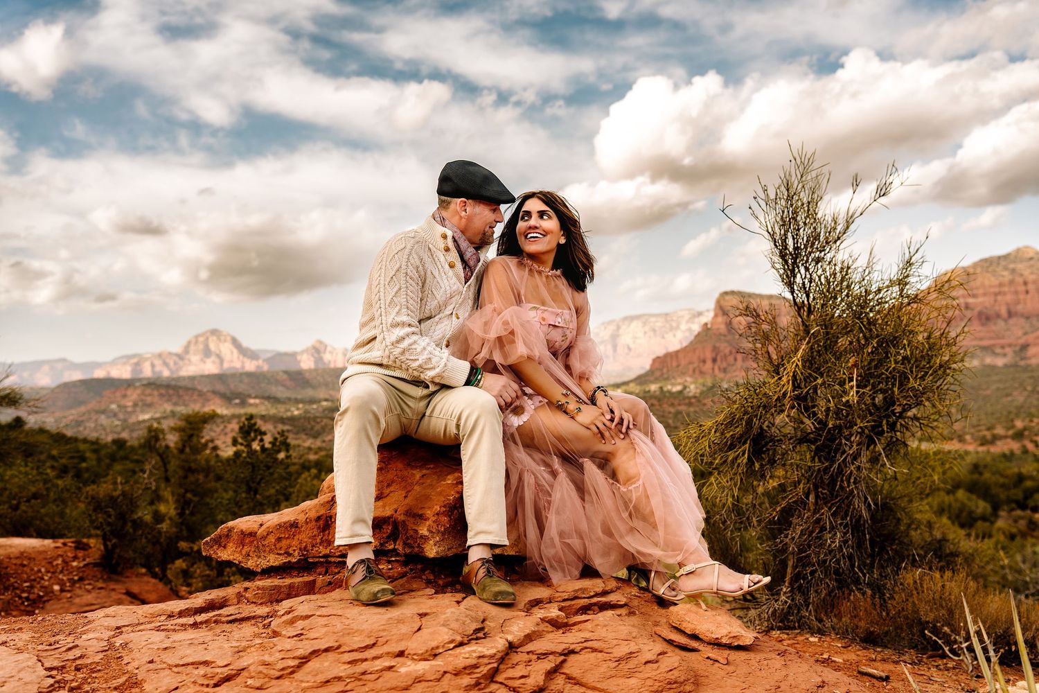 A romantic moment between a couple against majestic Sedona red rock formations.