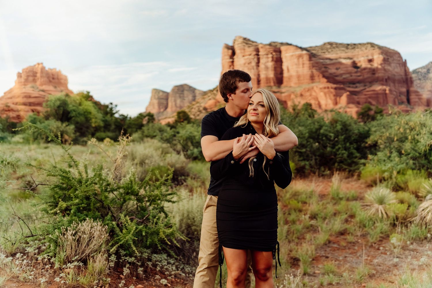 A romantic moment between a couple against majestic Sedona red rock formations.