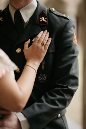 Close-up van een hand die een militair uniform aanraakt