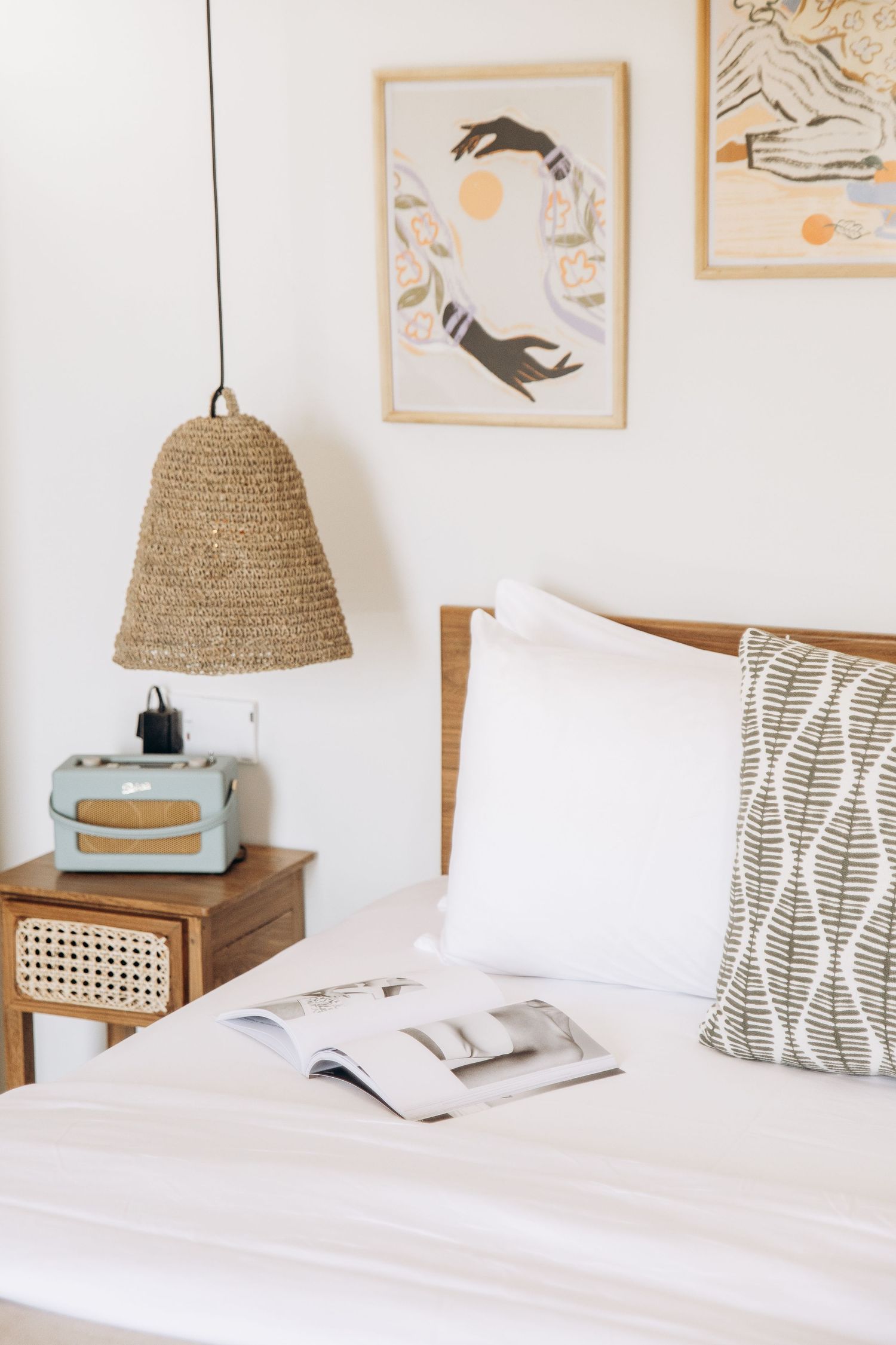 A serene coastal-themed bedroom with woven pendant lights and minimalist wall art.