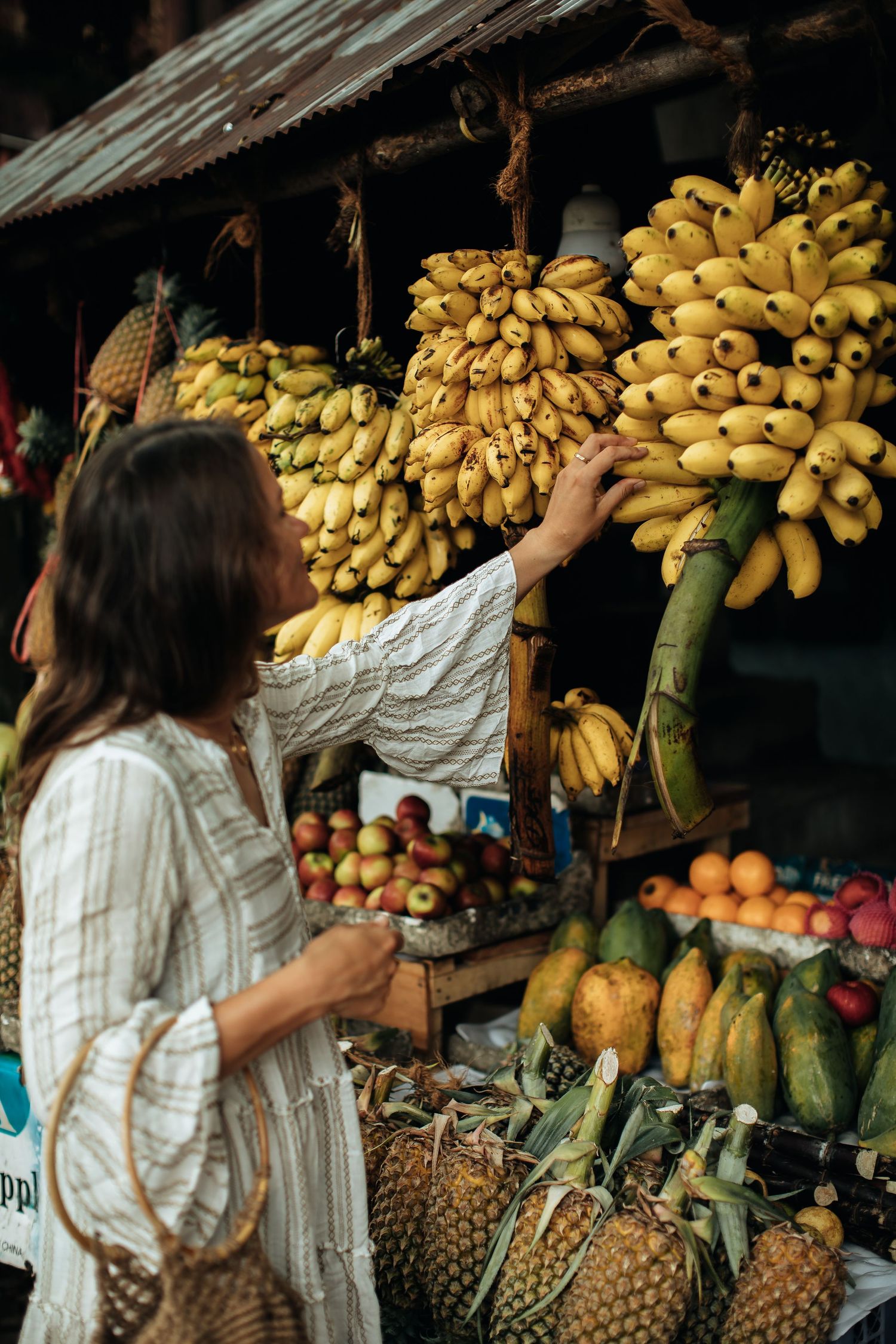 Fresh tropical fruits including bananas and pineapples displayed at an outdoor market stall.