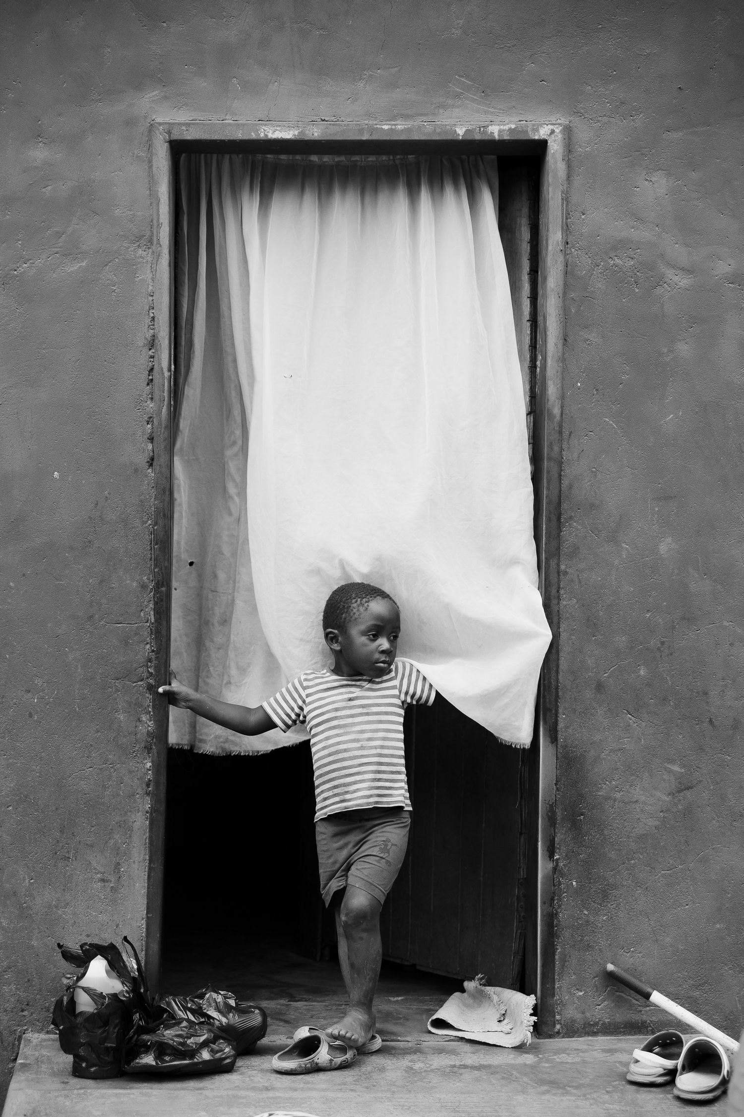Black and white photo series showing feet and legs behind white curtains.