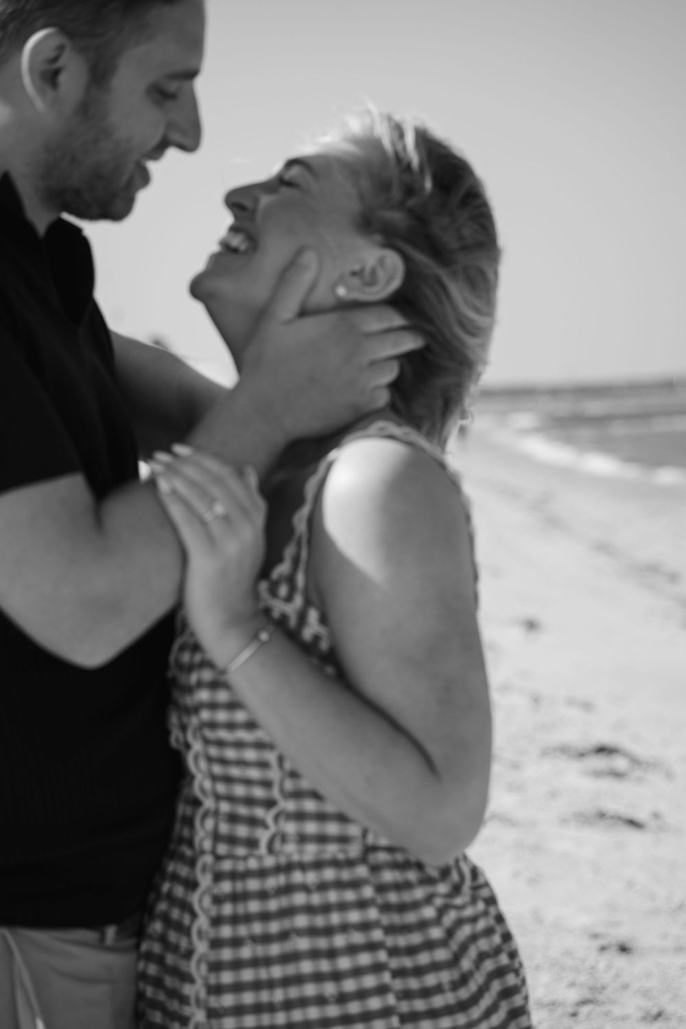 Black and white photo of romantic couple embracing on a Cape Cod beach, intimate and timeless