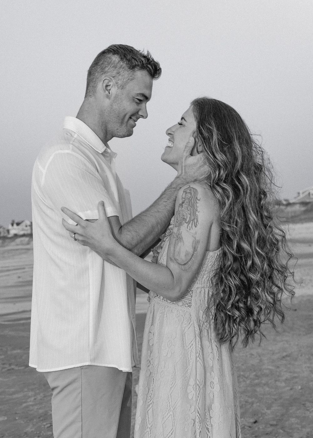 Romantic black and white photo of couple sharing an intimate moment on a Cape Cod beach