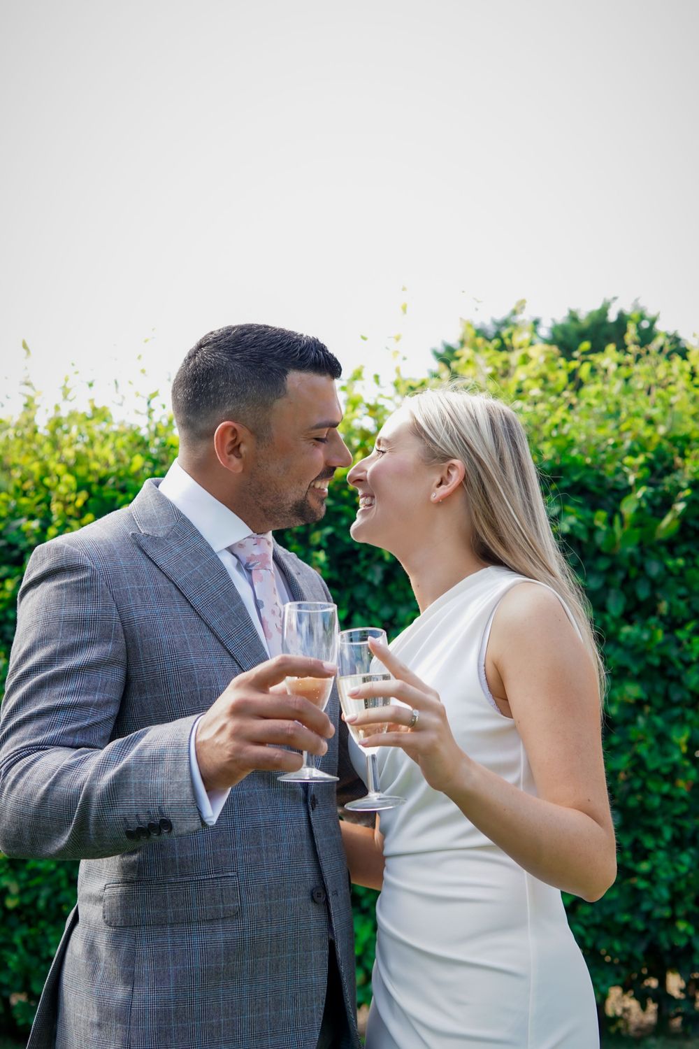 Romantic celebration, partners dressed up, clinking glasses and smiling outdoors.