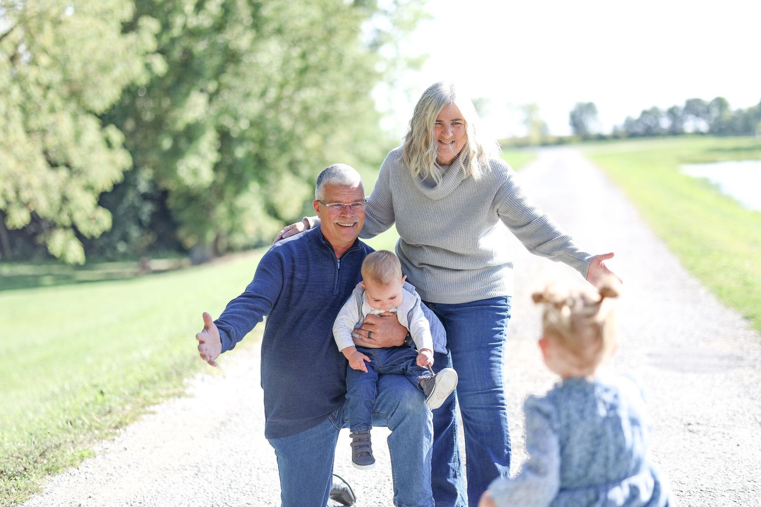 Family walking together on path with small children on sunny day in park.