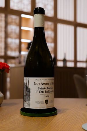 Close-up of Guy Amiot Saint-Aubin wine bottle featuring cathedral illustration on label.