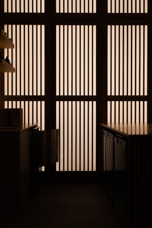 Interior with geometric window panels creating dramatic light and shadow patterns.