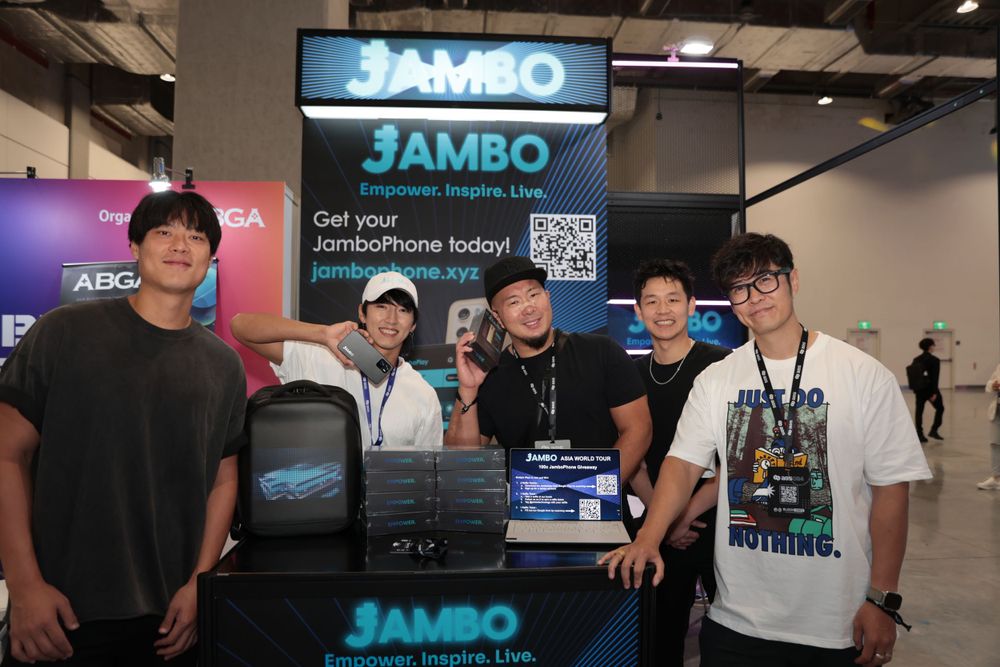 Group of five people pose together at Jambo Empower Inspire Live conference exhibition booth.