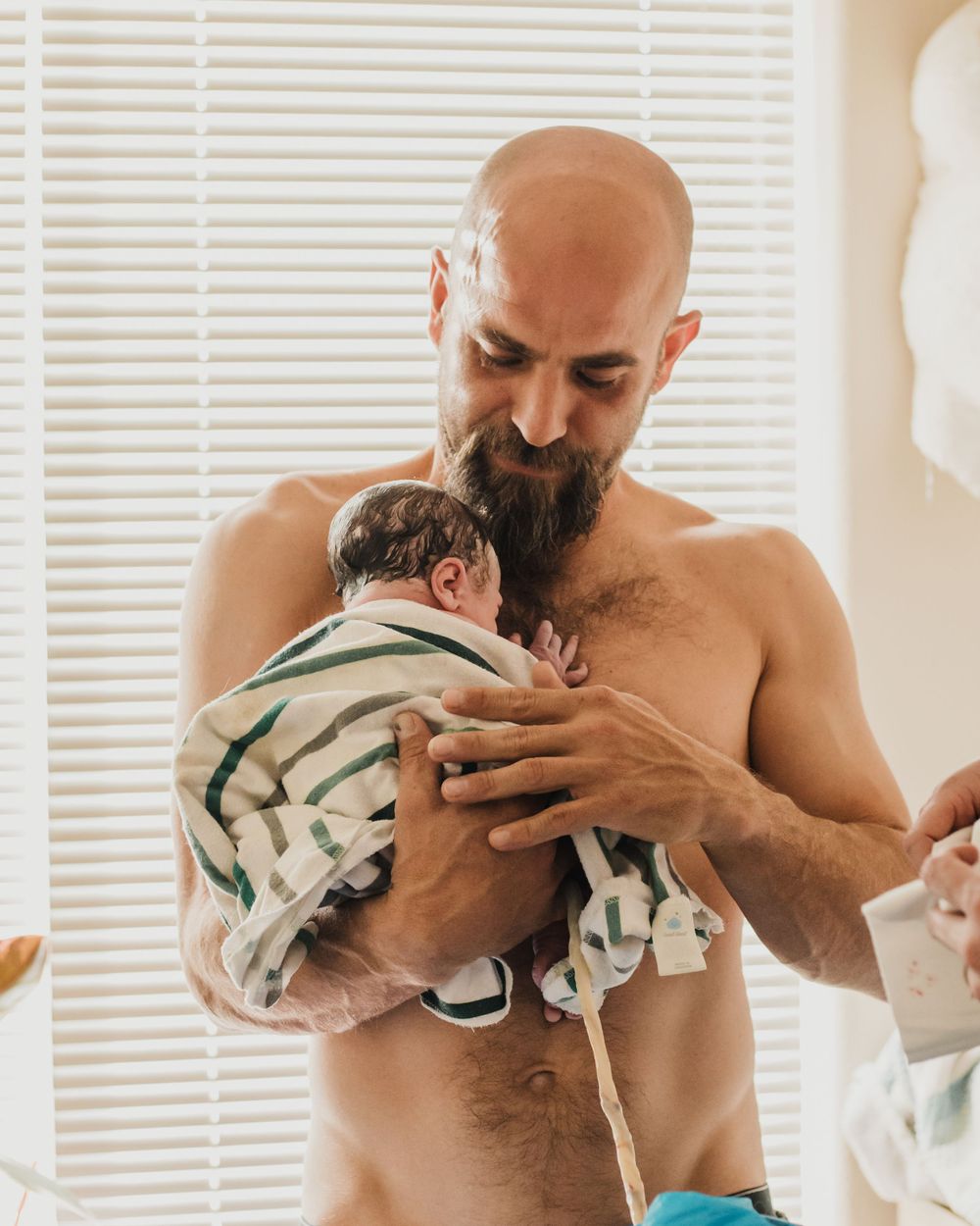 Dad enjoys skin to skin contact in the sunshine after this Carson Valley home birth with Ohana Birth Services