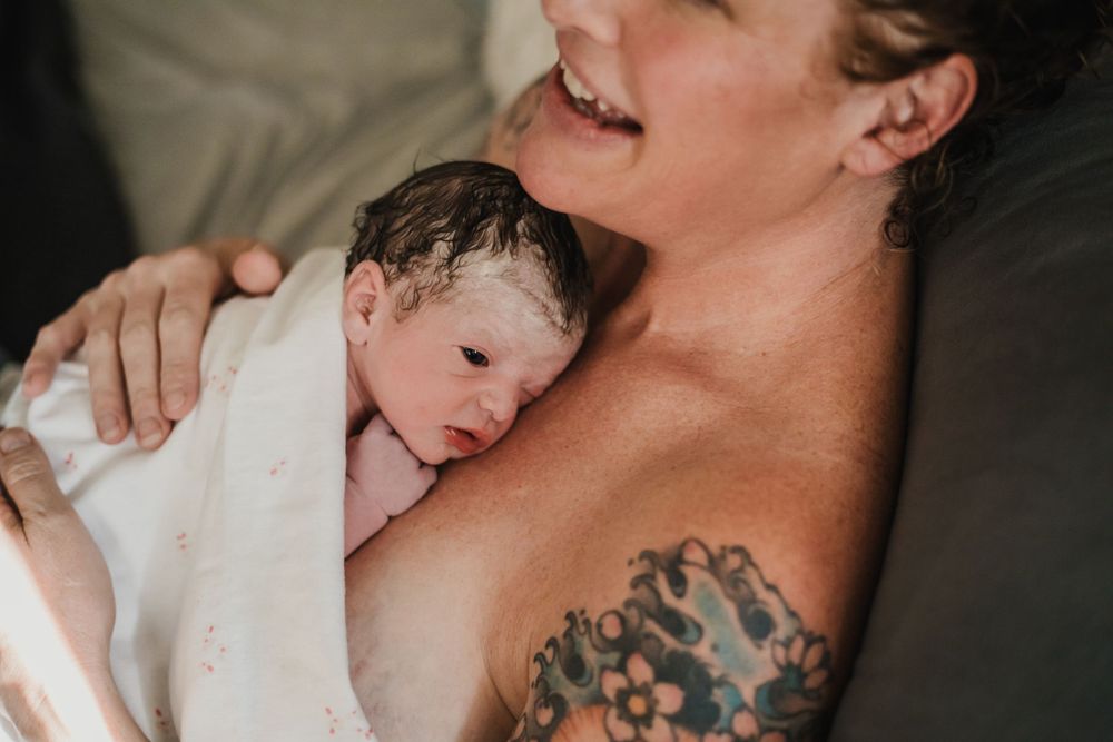 New born baby with eyes open resting on happy mom's chest after birth documenting birth stories Lake Tahoe / Carson