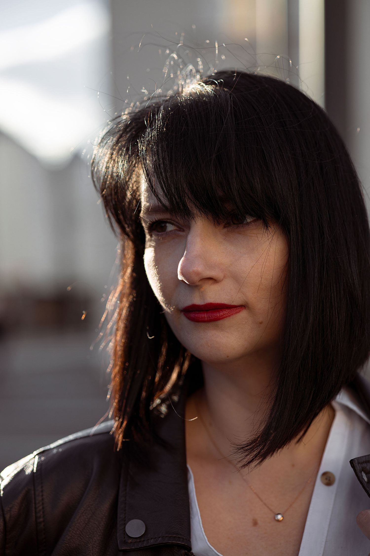 a brunette woman with a bob haircut looks into the distance. close-up portrait