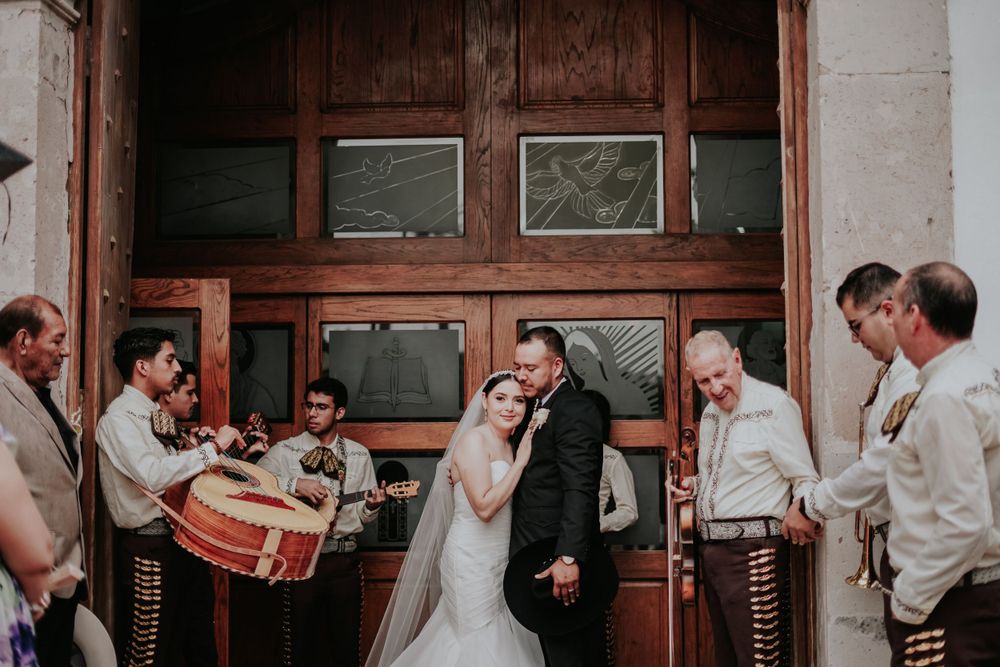 Wedding celebration with traditional musicians playing outside historic wooden doors.