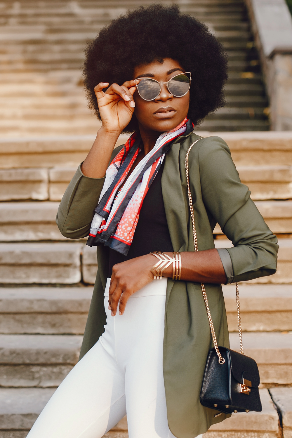 model in white pants and sunglasses