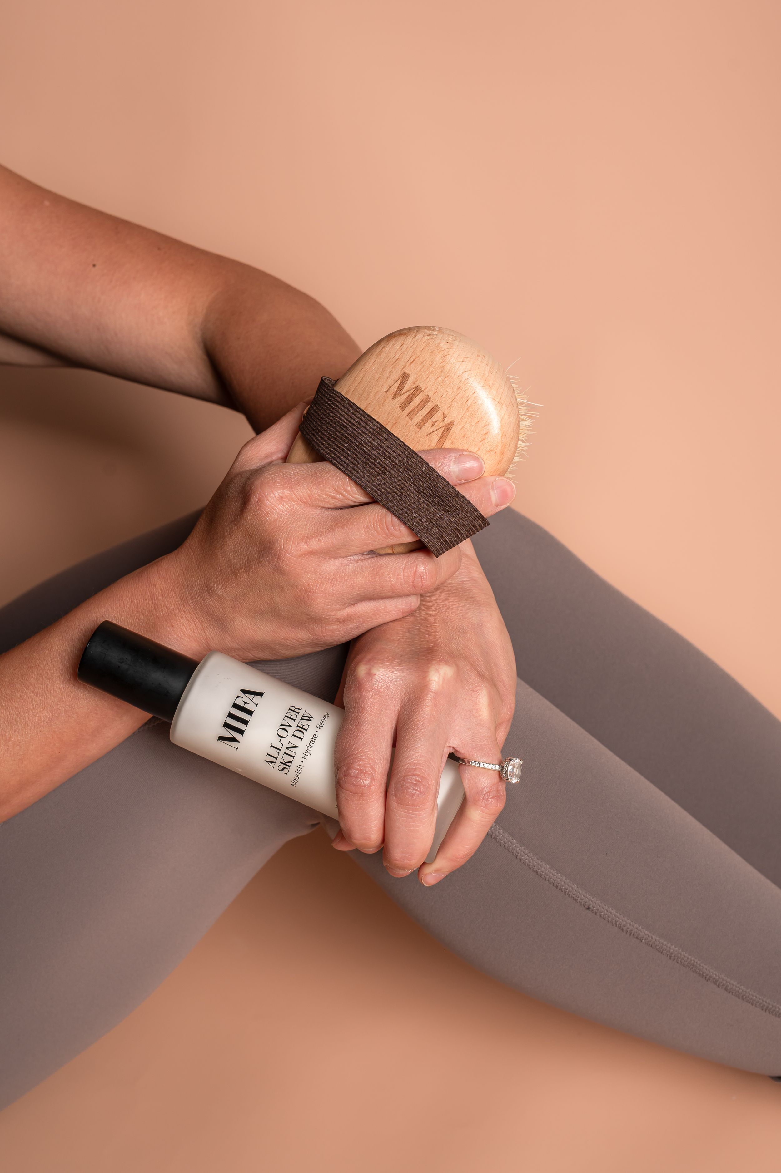Close-up shots of hands applying nail polish on a gray surface against a peach background.
