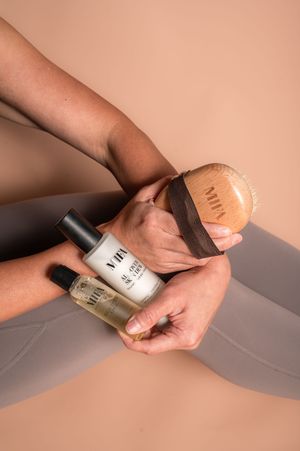 Hands demonstrating nail polish application techniques against a peach-colored backdrop.