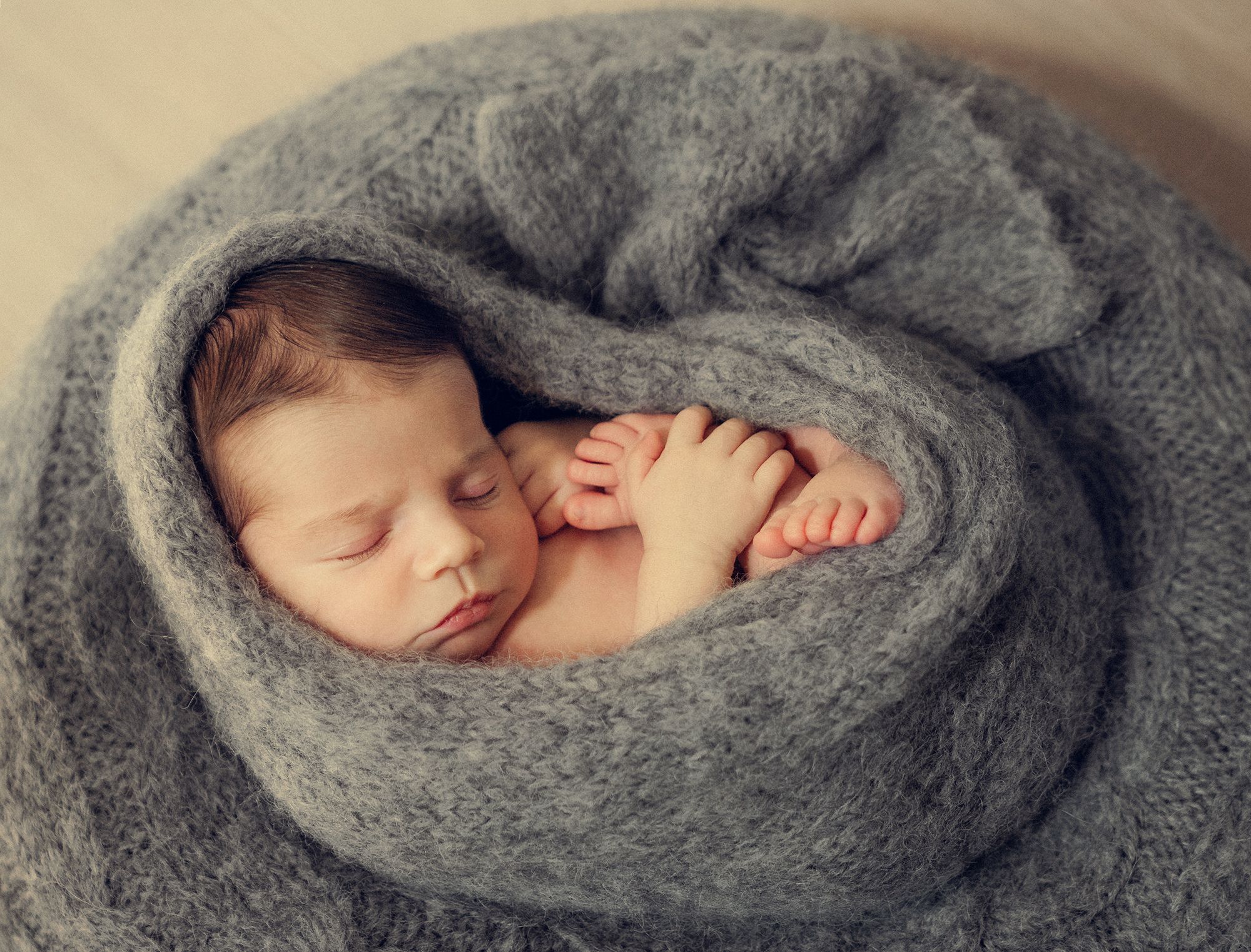 cocoon wrapping for a baby boy during the newborn photo session at home in Woodbridge