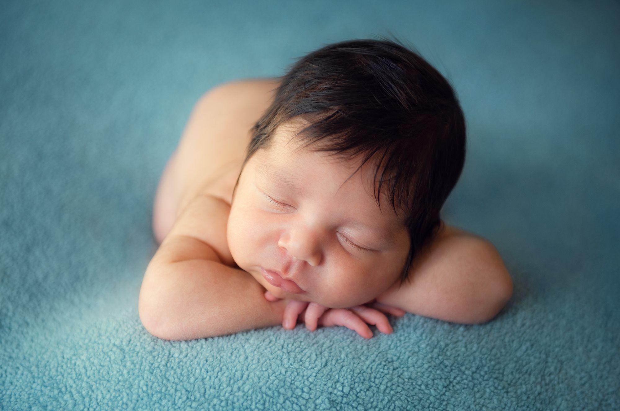 hands under the chin pose for a baby during the newborn photoshoot at home using the window light in Richmond Hill, On