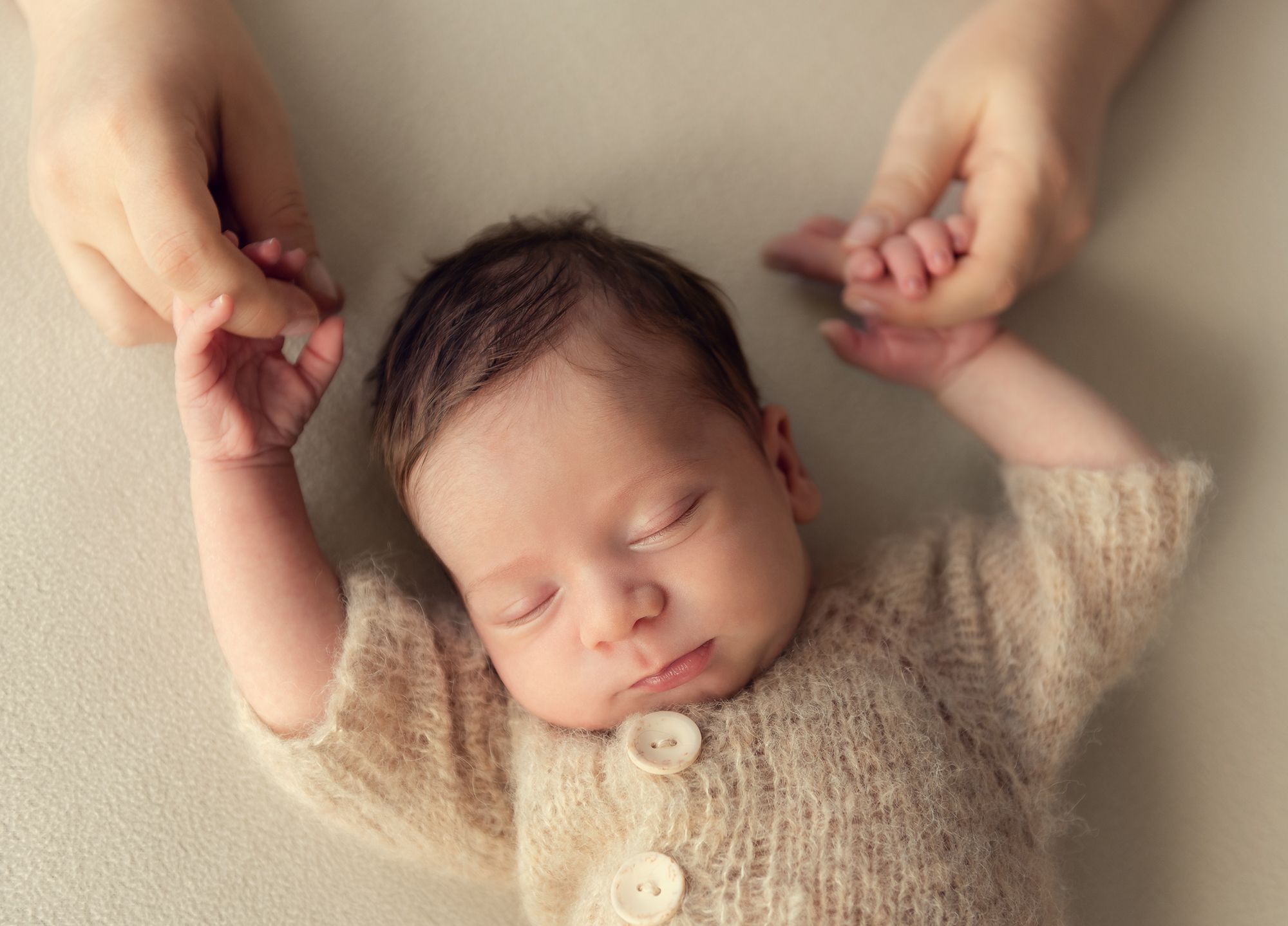 newborn baby boy is holding momma's fingers during the home photo session in Toronto, Ontario