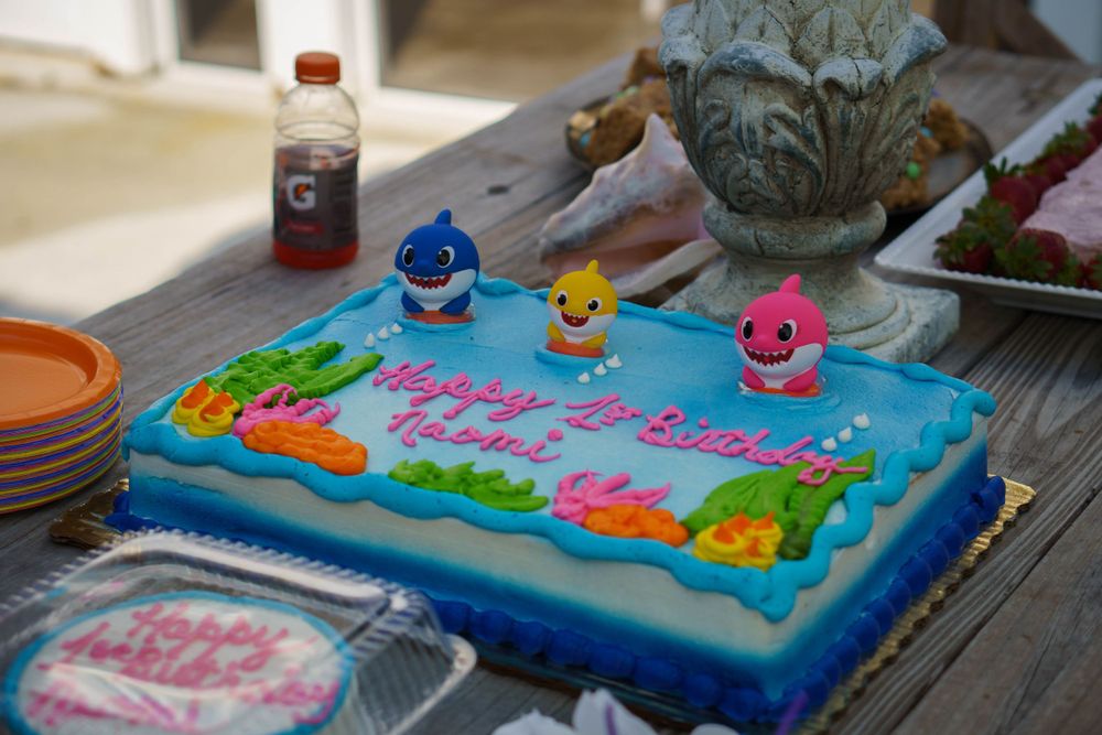 Baby Shark themed birthday cake with colorful frosting and character figurines on a decorated party table in Tampa.