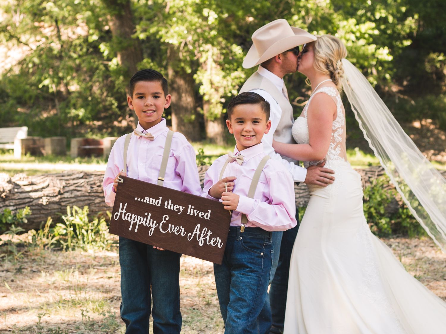 Bride and groom sharing a kiss with nephews close by