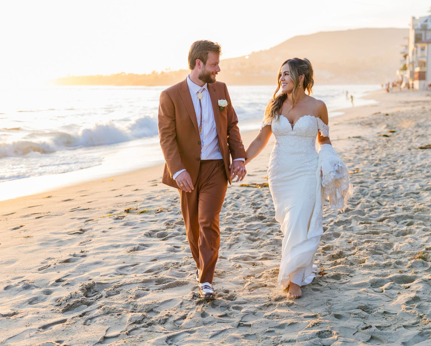 Bride and groom walking on the beach at golden hour at Laguna Beach