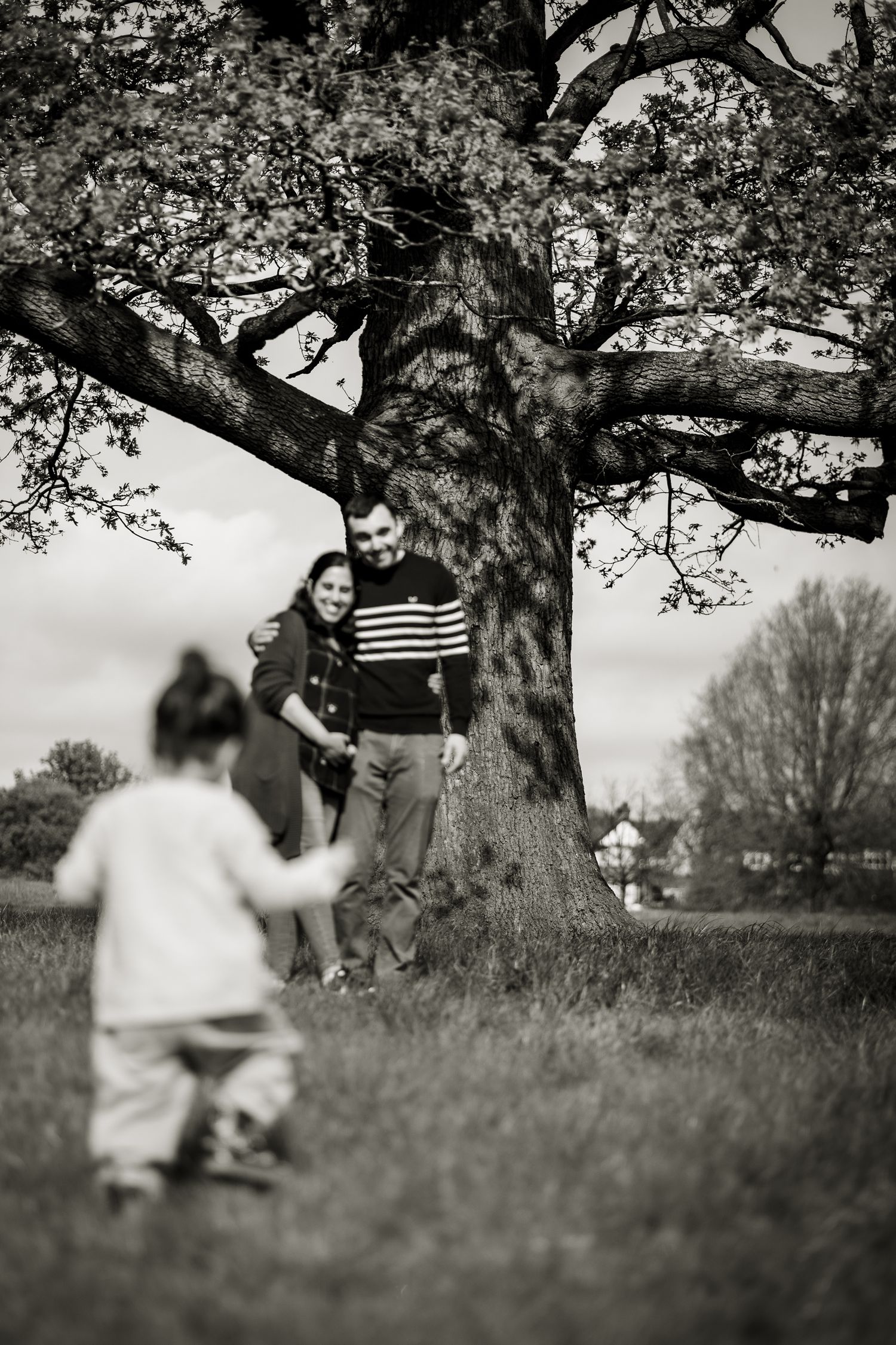 Girl running towards her parents on outdoor family shoot in local park