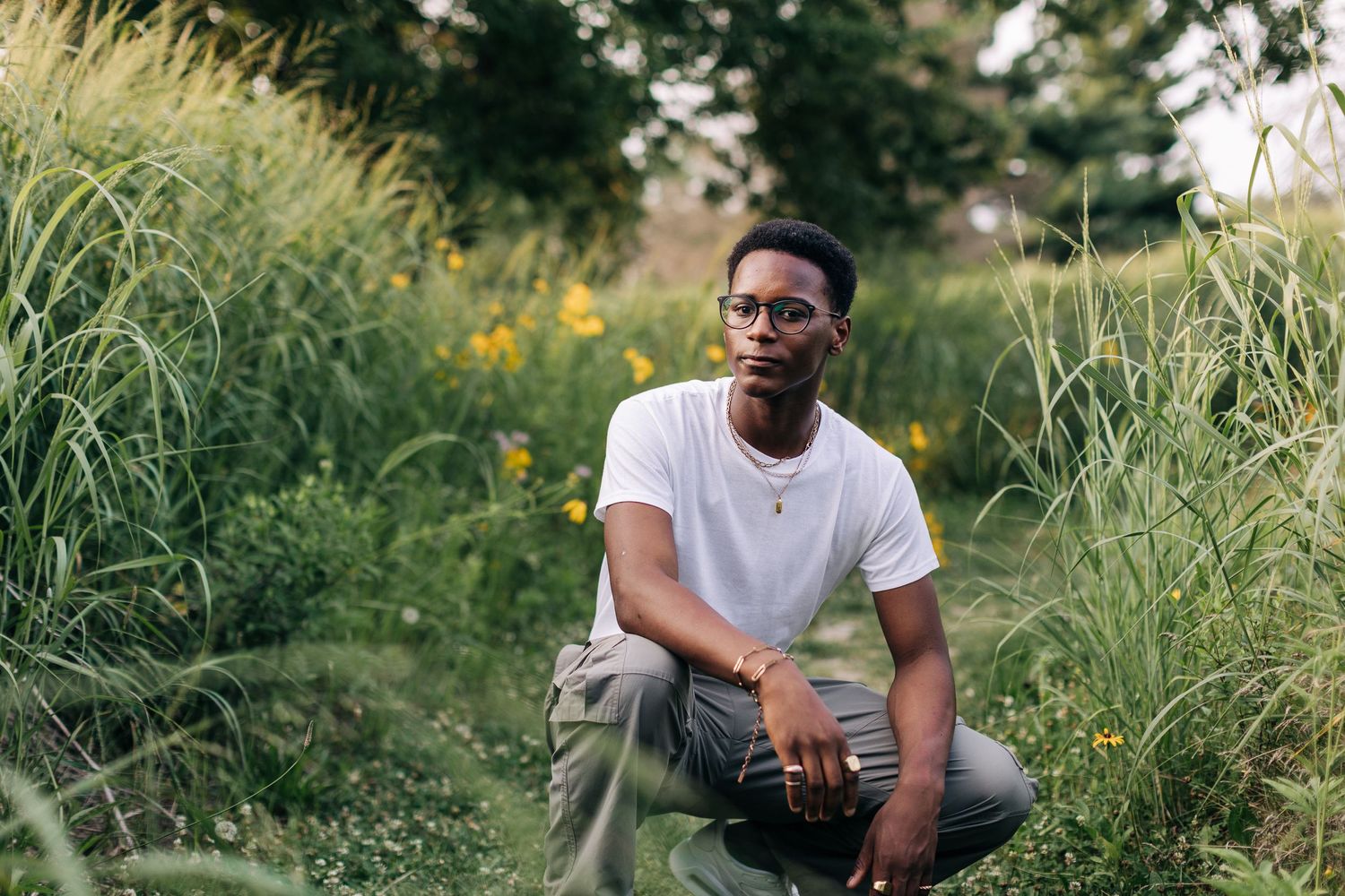 Casual outdoor portrait among wildflowers and tall grass.