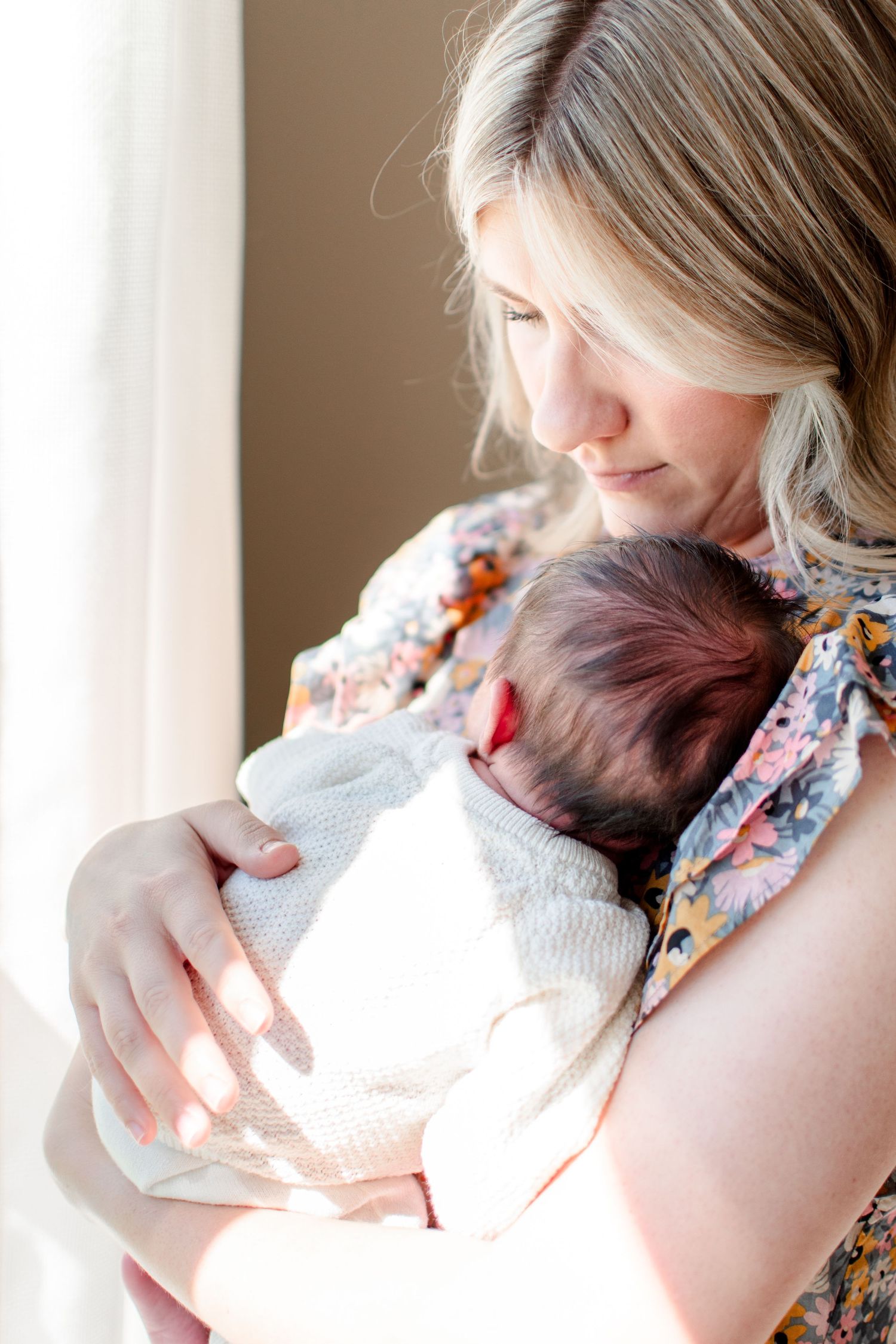 Mom snuggles baby girl close to her chest.