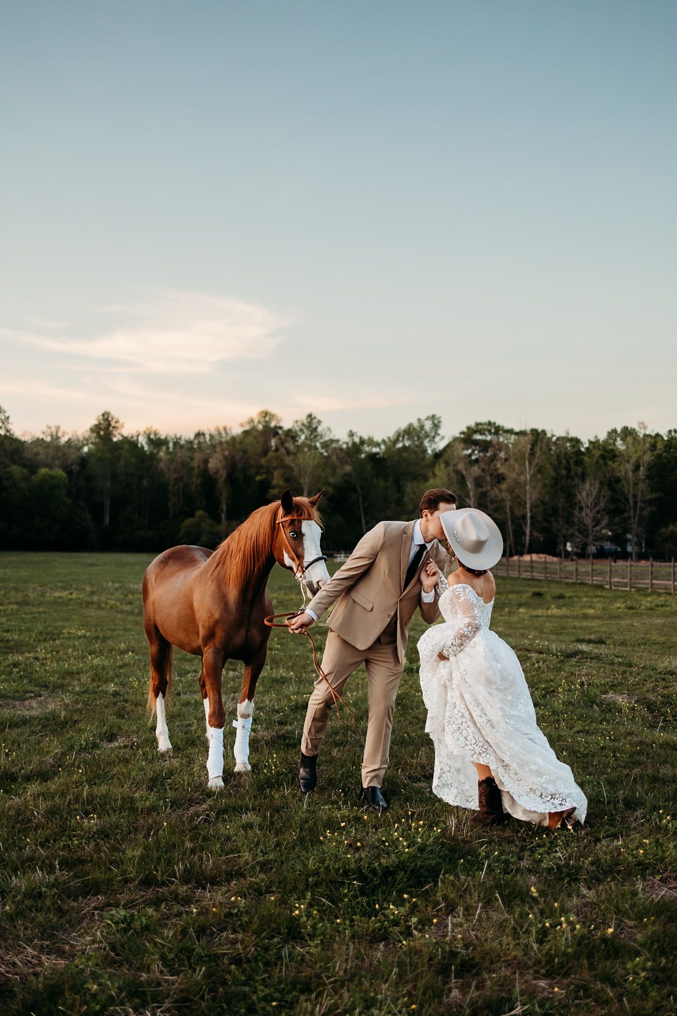 groom leaning over to kiss bride while walking a horse