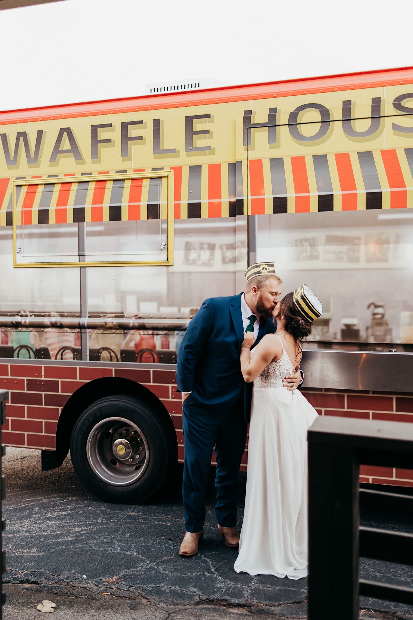 bride and groom wearing waffle house hats in front of a waffle house food truck