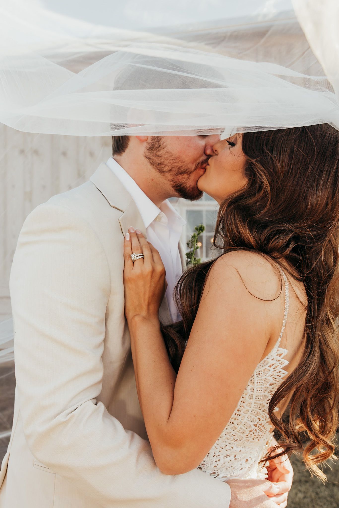 bride and groom kissing under her veil