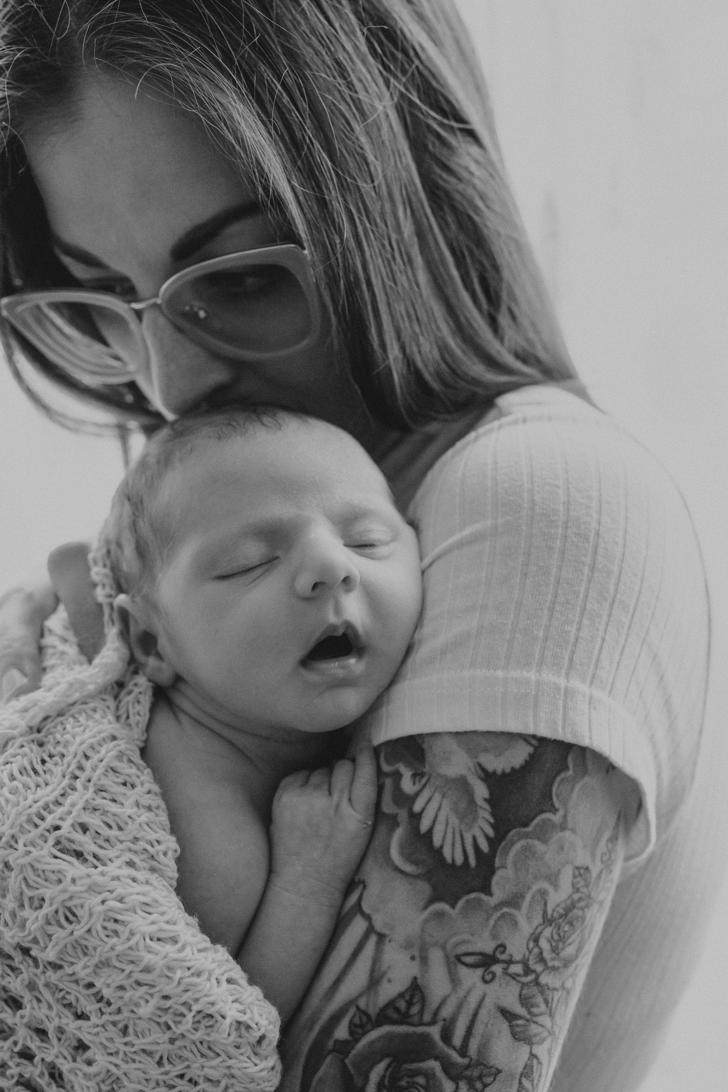 Black and white portrait of a sleeping newborn with delicate lace details.