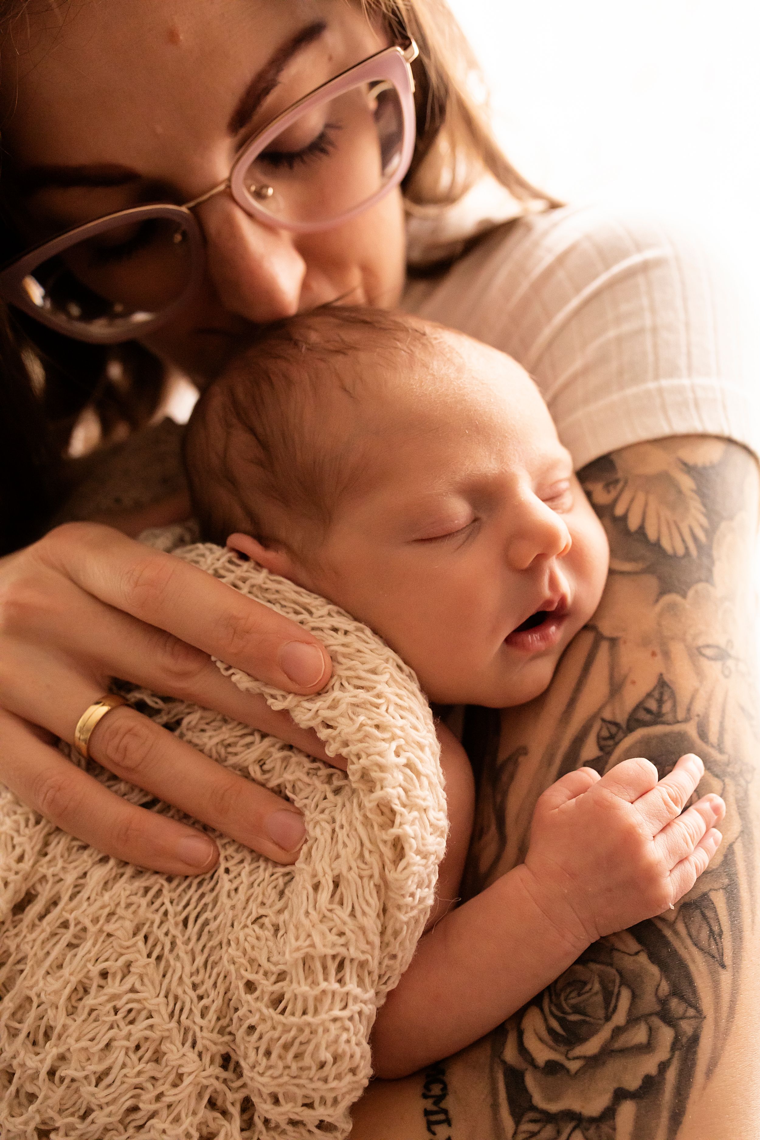 Artistic newborn photography with soft lighting and textured lace details.