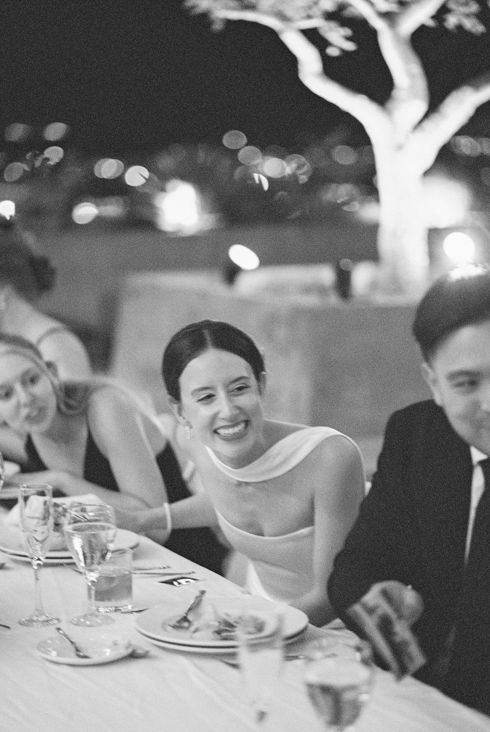 Wedding reception guests seated at tables enjoying a festive dinner celebration with ambient lighting.