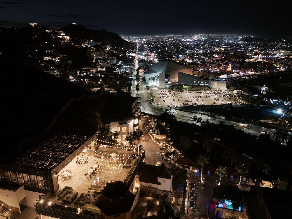 Panoramic aerial view of illuminated city buildings and streets at night showing urban landscape and architecture.