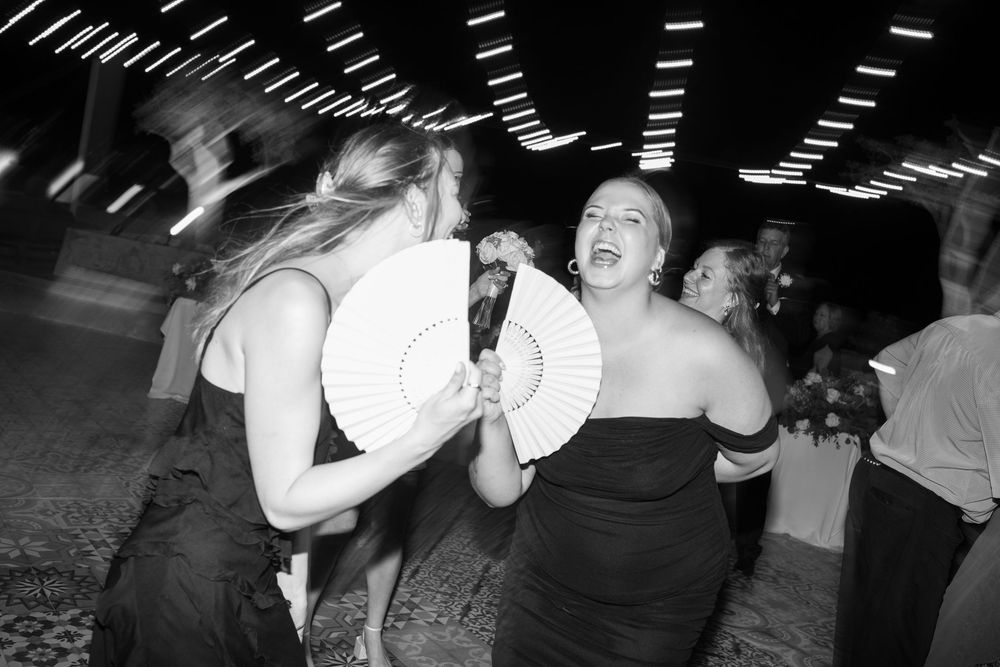Black and white photo of people dancing and having fun at a nighttime party event.
