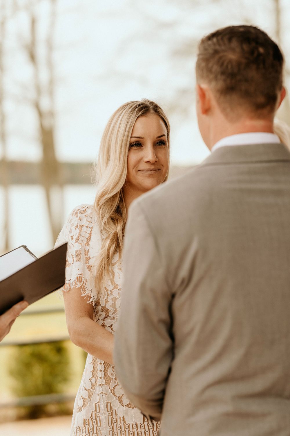 A bride and groom exchange vows during an intimate outdoor wedding ceremony.