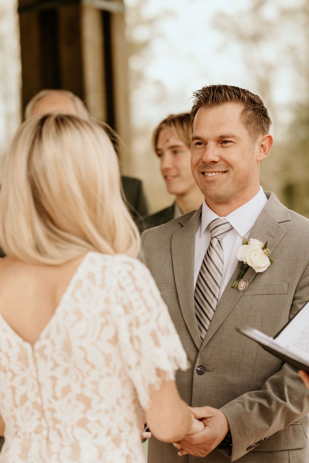 Wedding couple holds hands while exchanging vows in a heartfelt ceremony.