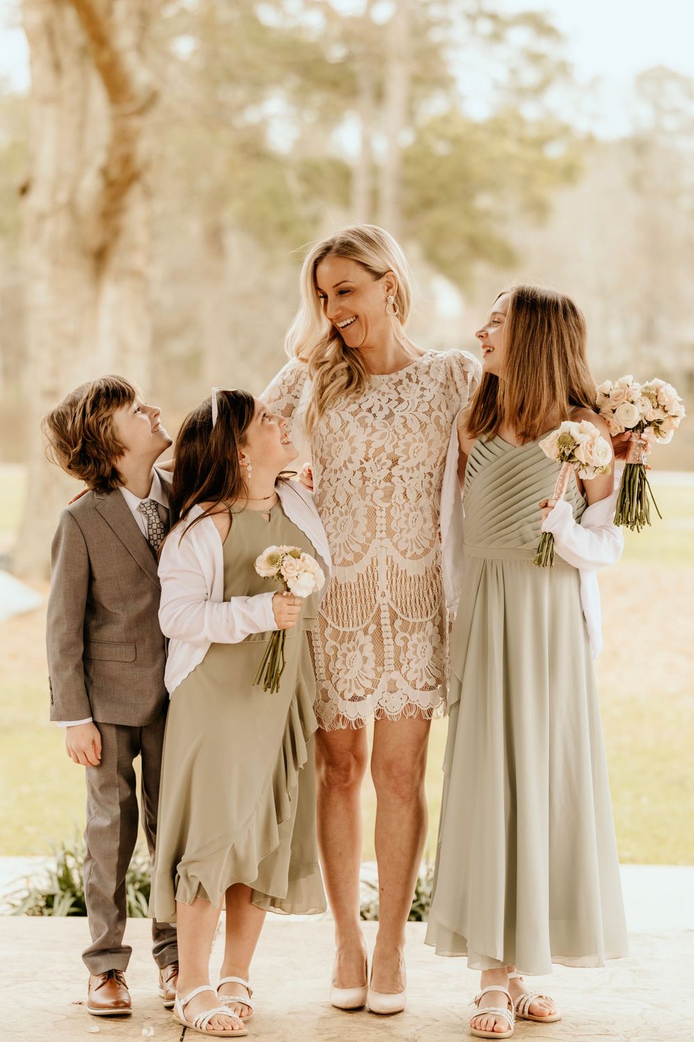 A sweet moment between the bride and children in coordinating wedding attire.