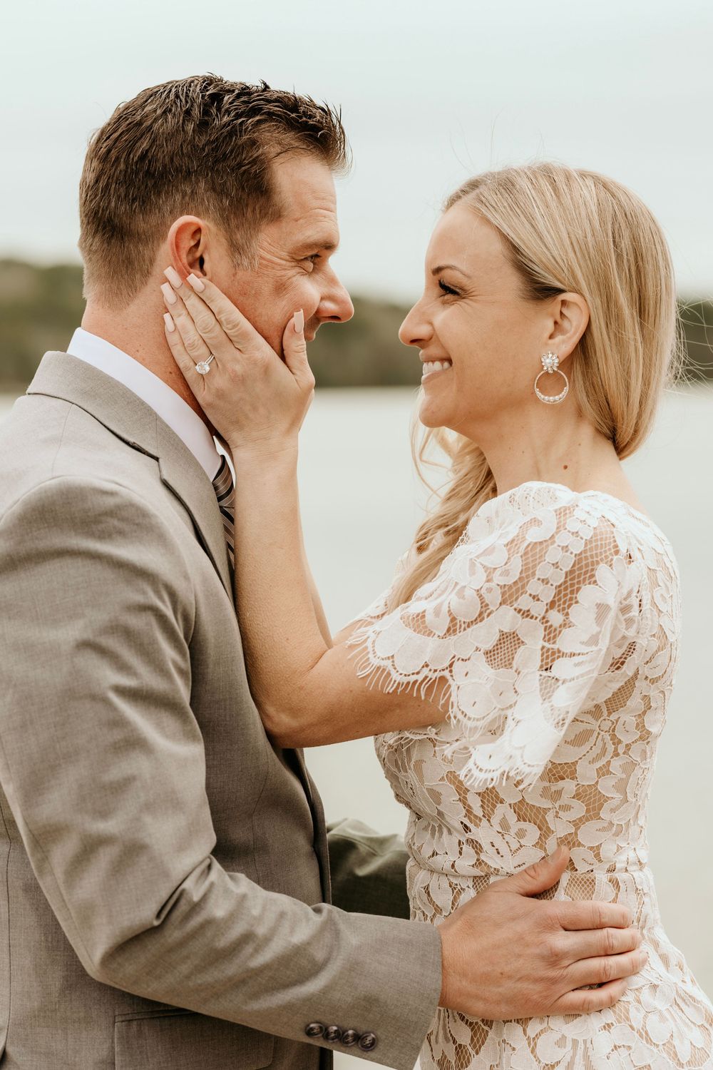 Intimate moment between newlyweds sharing tender touches and smiles.
