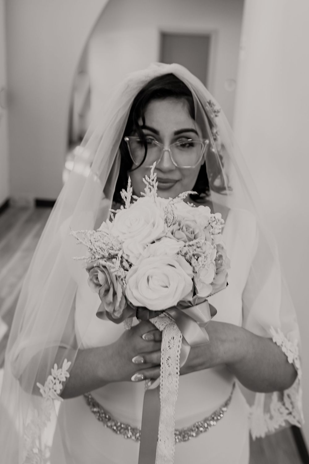 Close-up of bridal bouquet with white roses and delicate lace details.