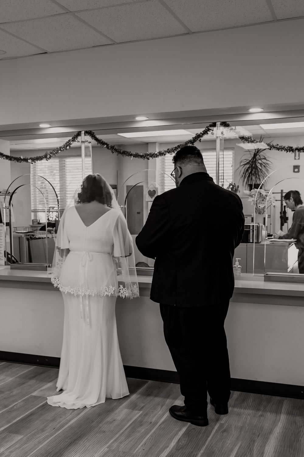Wedding attire displayed in a dance studio with mirrors and garland decorations.