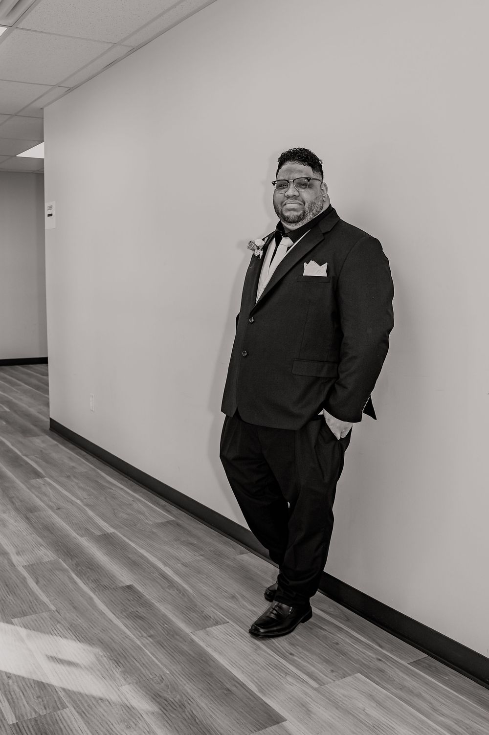 Black and white portrait session in a modern hallway setting.