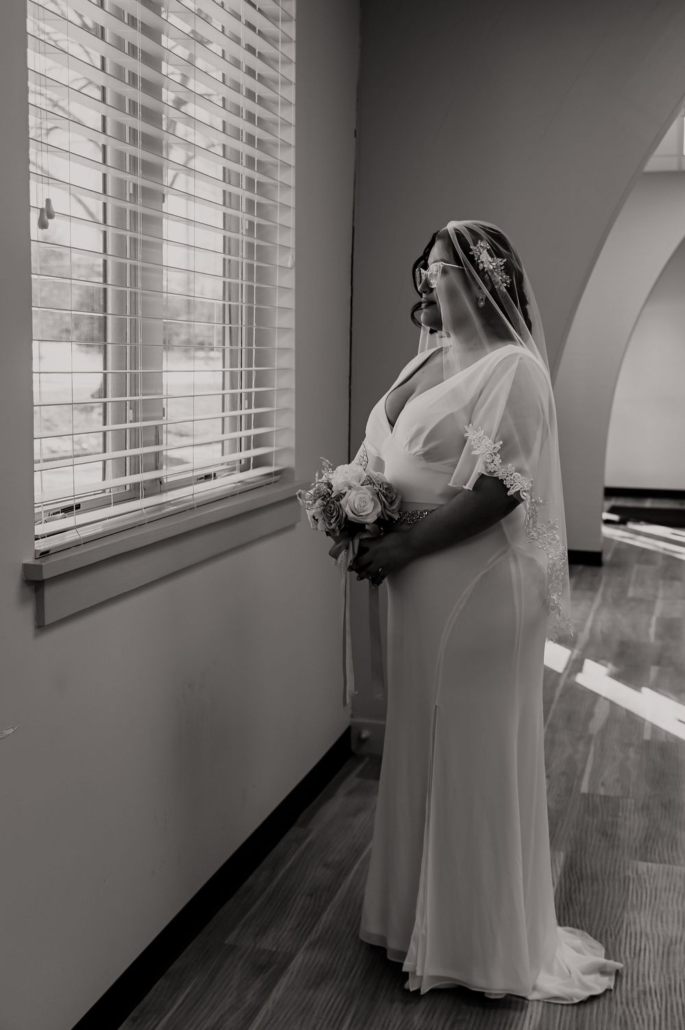 Elegant bridal portrait near a window with natural light streaming in.